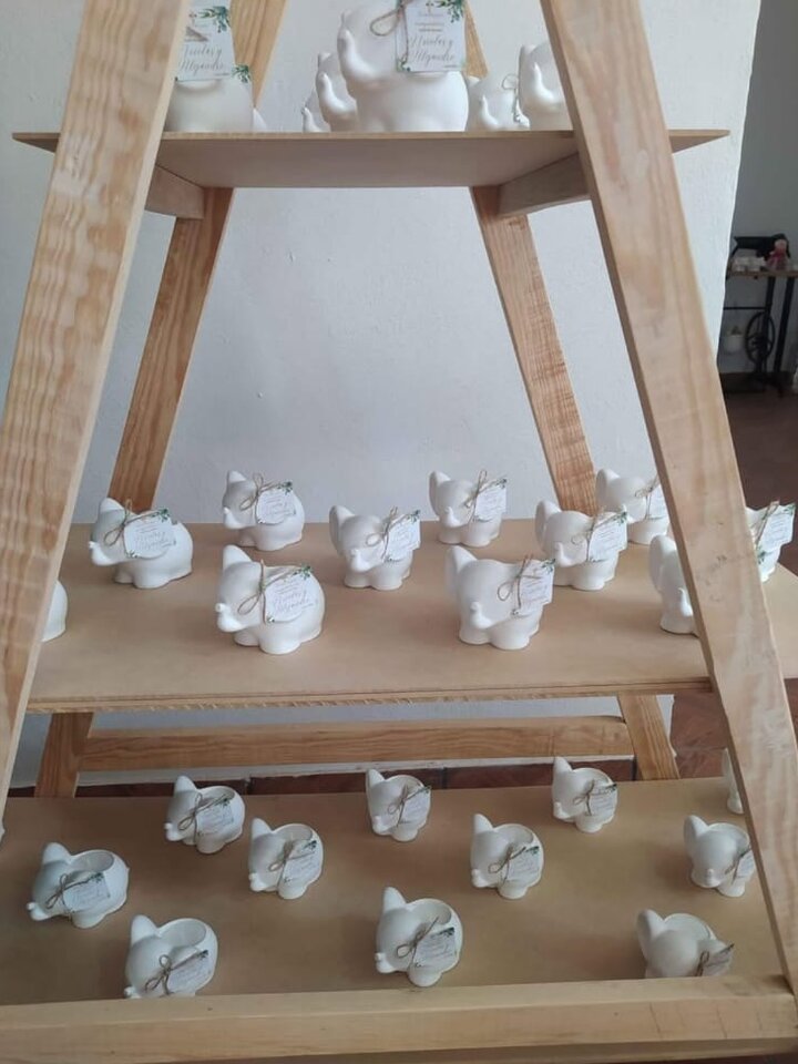 Muchos recuerdos de elefante en un estante, listos para un evento